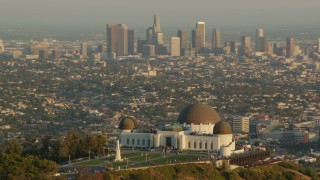 HDA06_09 - HD stock footage aerial video orbit the Griffith Observatory at sunset, and reveal the Downtown Los Angeles skyline, California