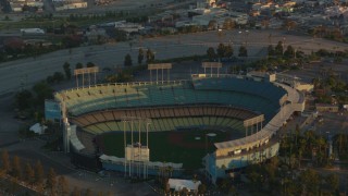 HDA06_18 - HD stock footage aerial video tilt from Dodger Stadium to reveal Los Angeles City Hall and Downtown Los Angeles at sunset