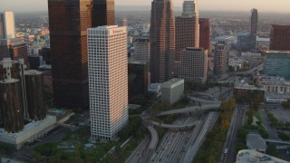 HDA06_44 - HD stock footage aerial video tilt from 110 freeway to reveal skyscrapers at sunset in Downtown Los Angeles, California