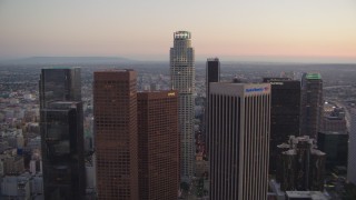 HDA06_75 - HD stock footage aerial video tilt up and flyby Bank of America Center to approach Paul Hastings Tower at twilight, Downtown Los Angeles, California