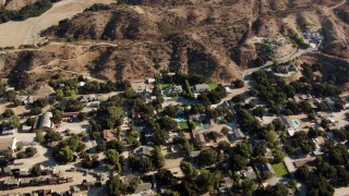 HDA07_17 - HD stock footage aerial video fly over homes and brown hills in Newhall, California