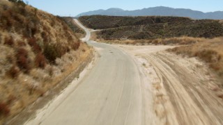 HDA07_22 - HD stock footage aerial video tilt and fly over a country road in the hills, Santa Clarita Valley, California