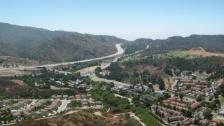 HDA07_26 - HD stock footage aerial video of fly over homes toward 14 freeway in Newhall, California