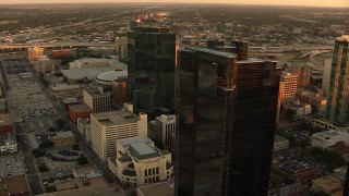 HDA12_005 - HD aerial stock footage video of flyby by skyscrapers at sunset to reveal high-rise hotel in Downtown Fort Worth, Texas