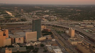 HDA12_013 - HD stock footage aerial video of flying away from freeway interchange to reveal skyscrapers at sunset in Downtown Fort Worth, Texas