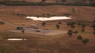 HDA12_035 - HD stock footage aerial video of a pond and silos on a farm at sunrise in Decatur, Texas