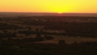 HDA12_038 - HD stock footage aerial video of the rising sun beyond farms and rural homes in Decatur, Texas