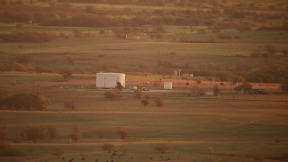 HDA12_052 - HD stock footage aerial video of a large tank and farmland at sunrise, Red River, Texas