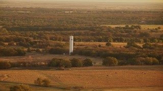 HDA12_067 - HD stock footage aerial video of flying by a silo on a farm at sunrise in Oklahoma