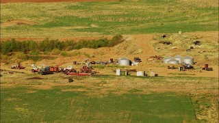 HDA12_085 - HD stock footage aerial video of tractors and tanks by fields in Walters, Oklahoma