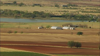 HDA12_100 - HD stock footage aerial video of farmland and barns by a lake in Temple, Oklahoma