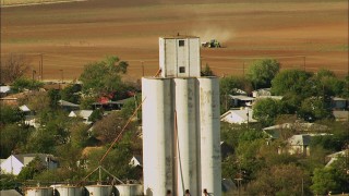 HDA12_102 - HD stock footage aerial video of silos and a tractor working a field in Temple, Oklahoma