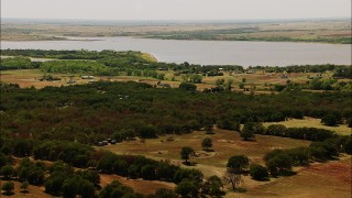 HDA12_109 - HD stock footage aerial video of fly over farms to approach a lake in Oklahoma