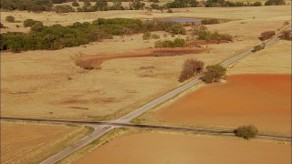 HDA12_121 - HD stock footage aerial video pass by country road and farmland with cows grazing near pond in Oklahoma