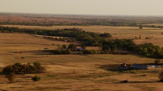 HDA12_129 - HD stock footage aerial video of a farmhouse and fields at sunset in Oklahoma