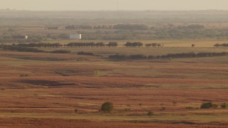 HDA12_130 - HD stock footage aerial video of large tanks and farmland at sunset in Oklahoma