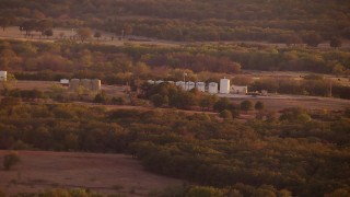 HDA12_152 - HD stock footage aerial video of large tanks on a farm at sunset in Nocona, Texas