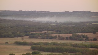 HDA12_162 - HD stock footage aerial video of smoke rising from trees at sunset in Texas