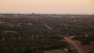 HDA12_172 - HD aerial stock footage video of rural homes, road near factory at sunset in Decatur, Texas
