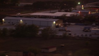 HDA12_179 - HD stock footage aerial video of a train running past an industrial building at night in Decatur, Texas