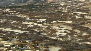 HDA13_284 - HD stock footage aerial video of flying over snowy fields and tilt to reveal homes and mountains, Castle Pines, Colorado