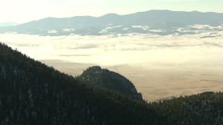 HDA13_306 - HD stock footage aerial video of a fog-shrouded valley and snowy Rocky Mountains, Park County, Colorado