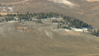 HDA13_330 - HD stock footage aerial video tilt from fields to reveal hills with snow and trees in Colorado