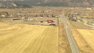 HDA13_349_01 - HD stock footage aerial video pan across a country highway to reveal the town of Ridgway, Colorado