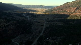 HDA13_392 - HD stock footage aerial video of following the highway at sunset toward rural homes in Ridgway, Colorado