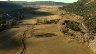 HDA13_395_01 - HD stock footage aerial video of tilting from highway and fields while approaching Ridgway, Colorado at sunset
