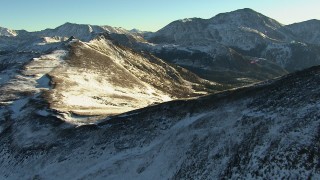 HDA13_445 - HD stock footage aerial video approach and fly over ridges with snow in the Rocky Mountains at sunrise, Colorado