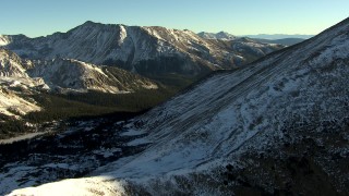HDA13_447 - HD stock footage aerial video of flying over a snowy mountain slope at sunrise, Rocky Mountains, Colorado