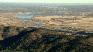HDA13_482_06 - HD stock footage aerial video zoom to wider view of Downtown Denver and reservoir, reveal Roxborough Park, Colorado