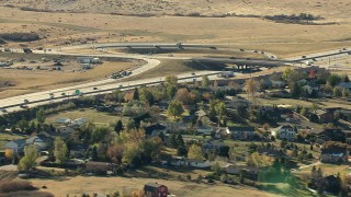 HDA13_486_02 - HD stock footage aerial video of a freeway interchange beside a suburban neighborhood in Castle Pines, Colorado