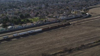 JDC01_084 - 5K aerial stock footage of tracking train traveling by suburban area, fields, Pittsburg, California