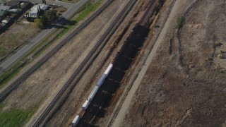 JDC01_086 - 5K aerial stock footage of tracking a train moving past residential neighborhoods, fields, Pittsburg, California