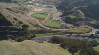 JDC02_006 - 5K aerial stock footage of Highway 24 freeway through hills, tilt to soccer fields, Orinda, California