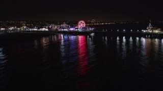 LD01_0039 - 5K stock footage aerial video tilt from the ocean to reveal Santa Monica Pier, California at night