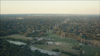 PP001_012 - HD aerial stock footage of fly over barns to approach power lines and homes at sunset in Orland Park, Illinois