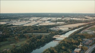 PP001_014 - HD aerial stock footage approach warehouses across the river with a bridge at sunset in Alsip, Illinois