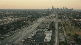 PP001_020 - HD aerial stock footage follow freeway and rail through South Side at sunset toward Downtown Chicago, Illinois