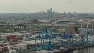 PP003_091 - HD stock footage aerial video of containers and cranes at a shipping port, with a view of Downtown Philadelphia skyline, Pennsylvania