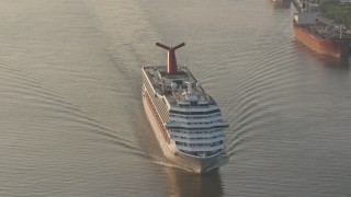 PVED01_012E - 4K aerial stock footage of Carnival Cruise ship sailing Mississippi River, reveal Downtown New Orleans at sunrise, Louisiana
