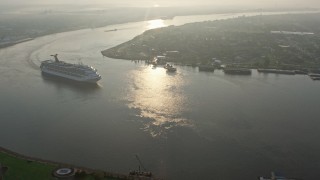 PVED01_029E - 4K aerial stock footage Carnival Cruise ship on the river to reveal Downtown New Orleans at sunrise, Louisiana