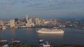 PVED01_030 - 4K aerial stock footage Carnival Cruise ship on the river to reveal Downtown New Orleans at sunrise, Louisiana