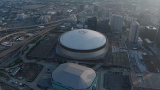 PVED01_043 - 4K aerial stock footage of the Superdome and New Orleans Arena in Downtown New Orleans, Louisiana at sunrise