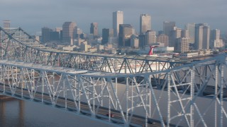 PVED01_046 - 4K aerial stock footage flyby Crescent City Connection Bridge and reveal Downtown New Orleans skyline at sunrise, Louisiana
