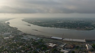 PVED01_057 - 4K aerial stock footage of a wide orbit of barges on the Mississippi River by the French Quarter of New Orleans at sunrise, Louisiana