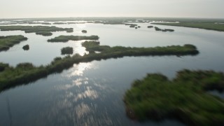 PVED01_072E - 4K aerial stock footage fly low over marshland and bayou to reveal surge barrier at sunrise in St. Bernard Parish, Louisiana
