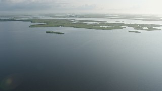 PVED01_074E - 4K aerial stock footage fly over patches of bayou marshland at sunrise in St. Bernard Parish and reveal surge barrier, Louisiana